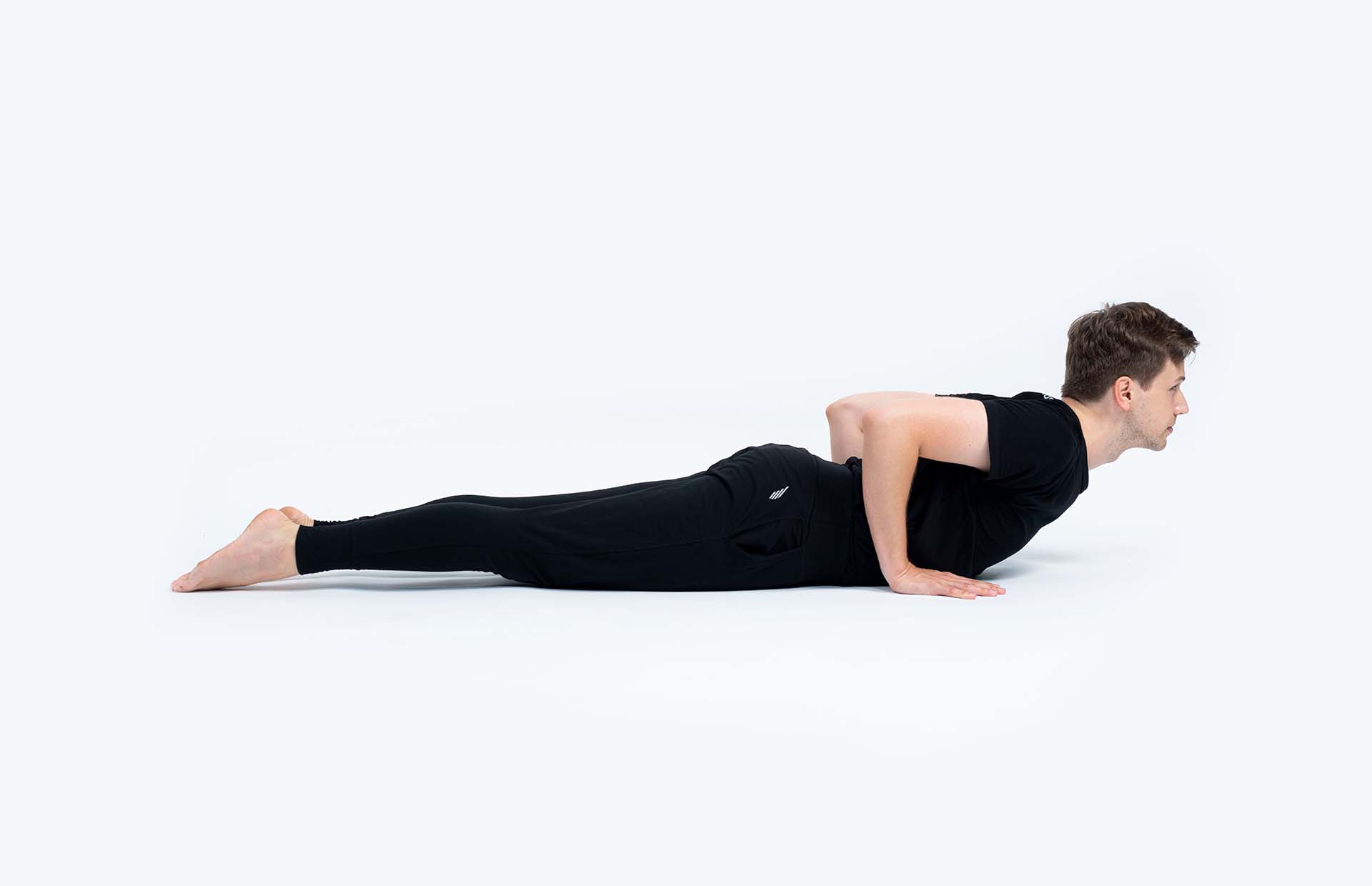 A person extending into Bhujangasana (Cobra Pose)
