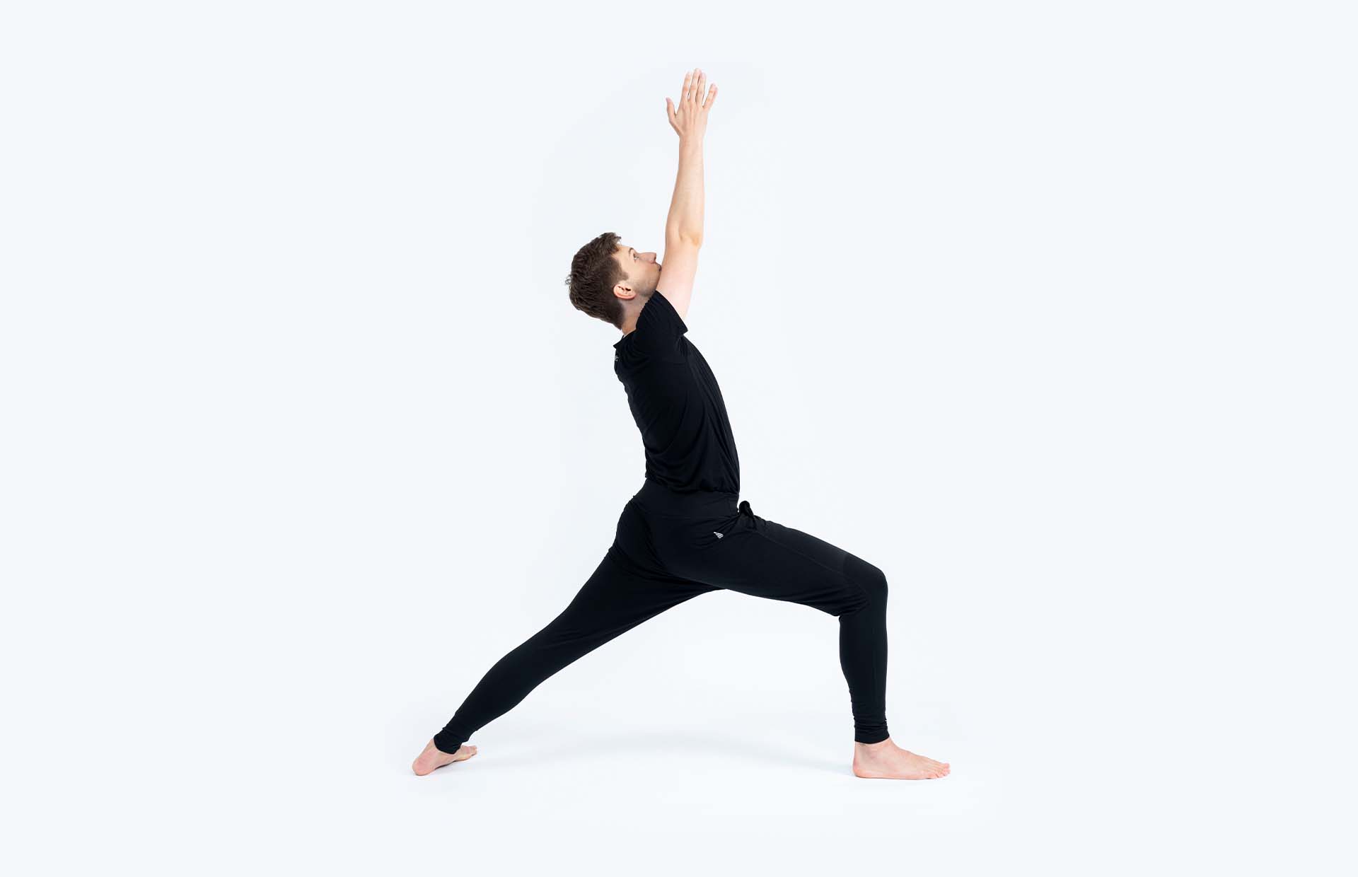 A person reaching up into Virabhadrasana 1 (Warrior 1)
