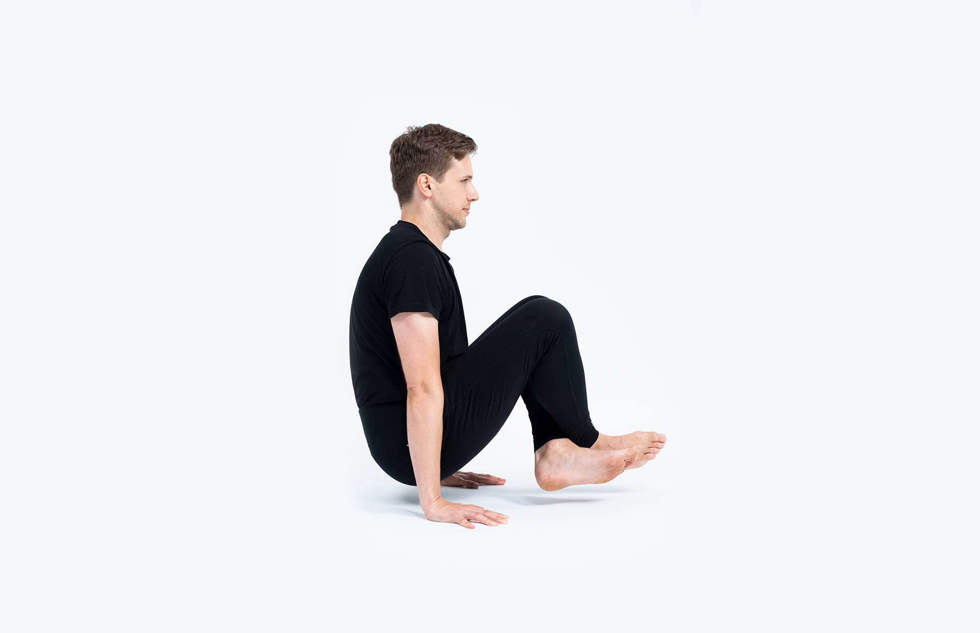 A person lifting in Lolasana (Pendant Pose)