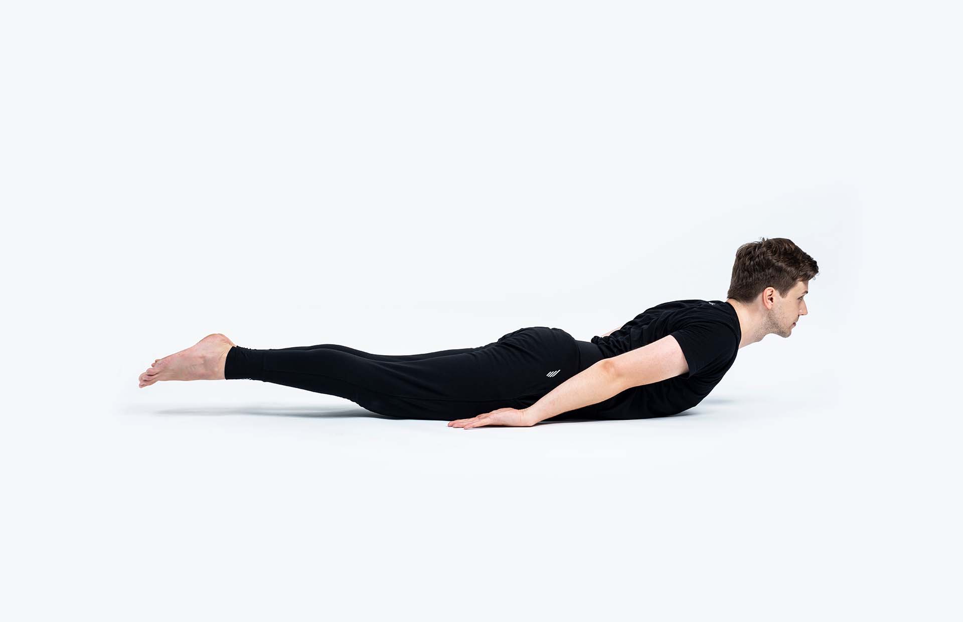 A person extending into Shalabhasana (Locust)