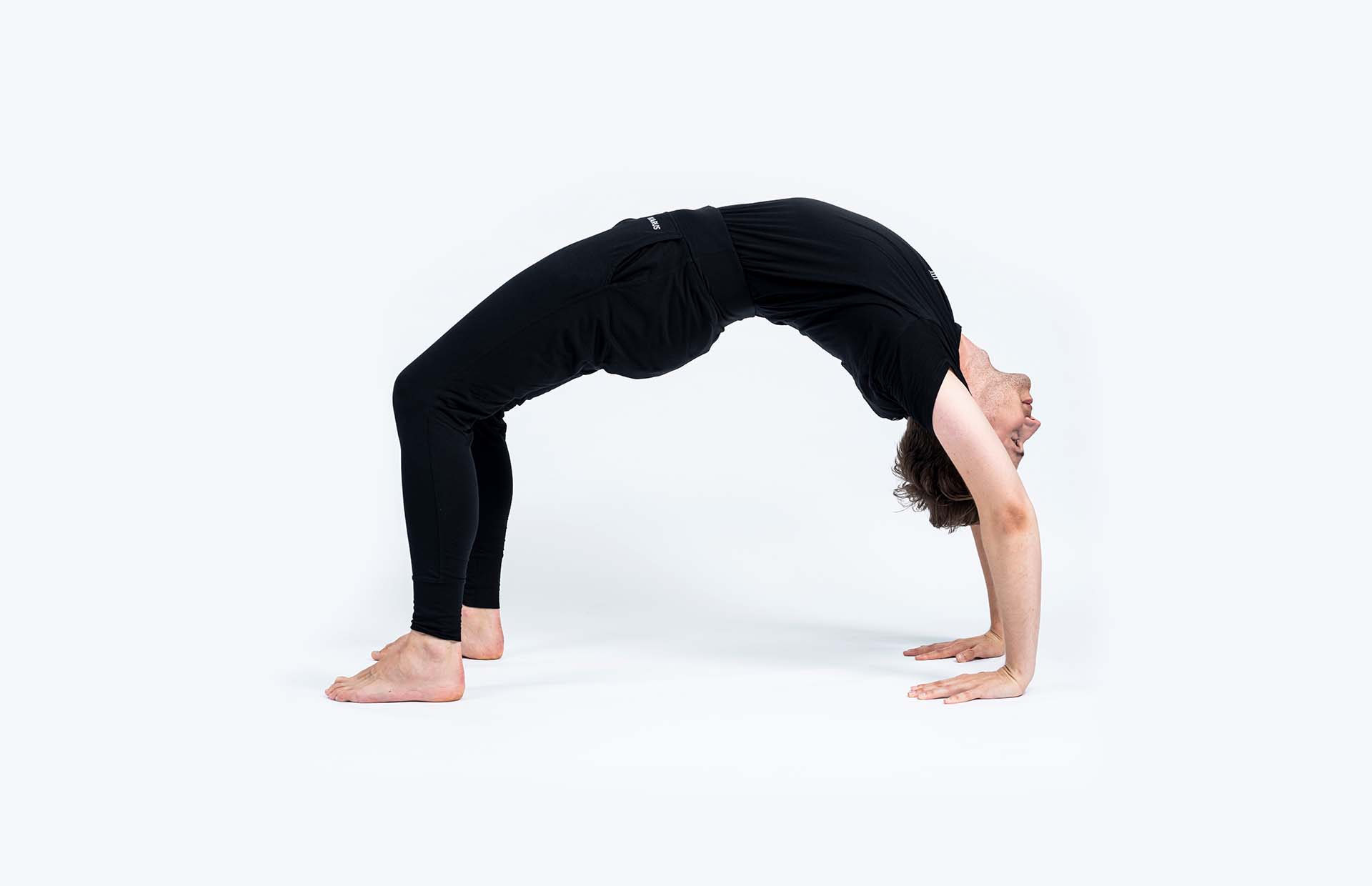 A person extending into Dhanurasana (Wheel Pose)