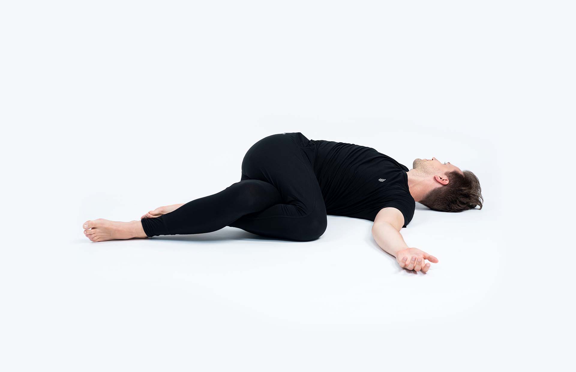 A person in Supta Parivrtta Garudasana (Reclining Eagle Twist)