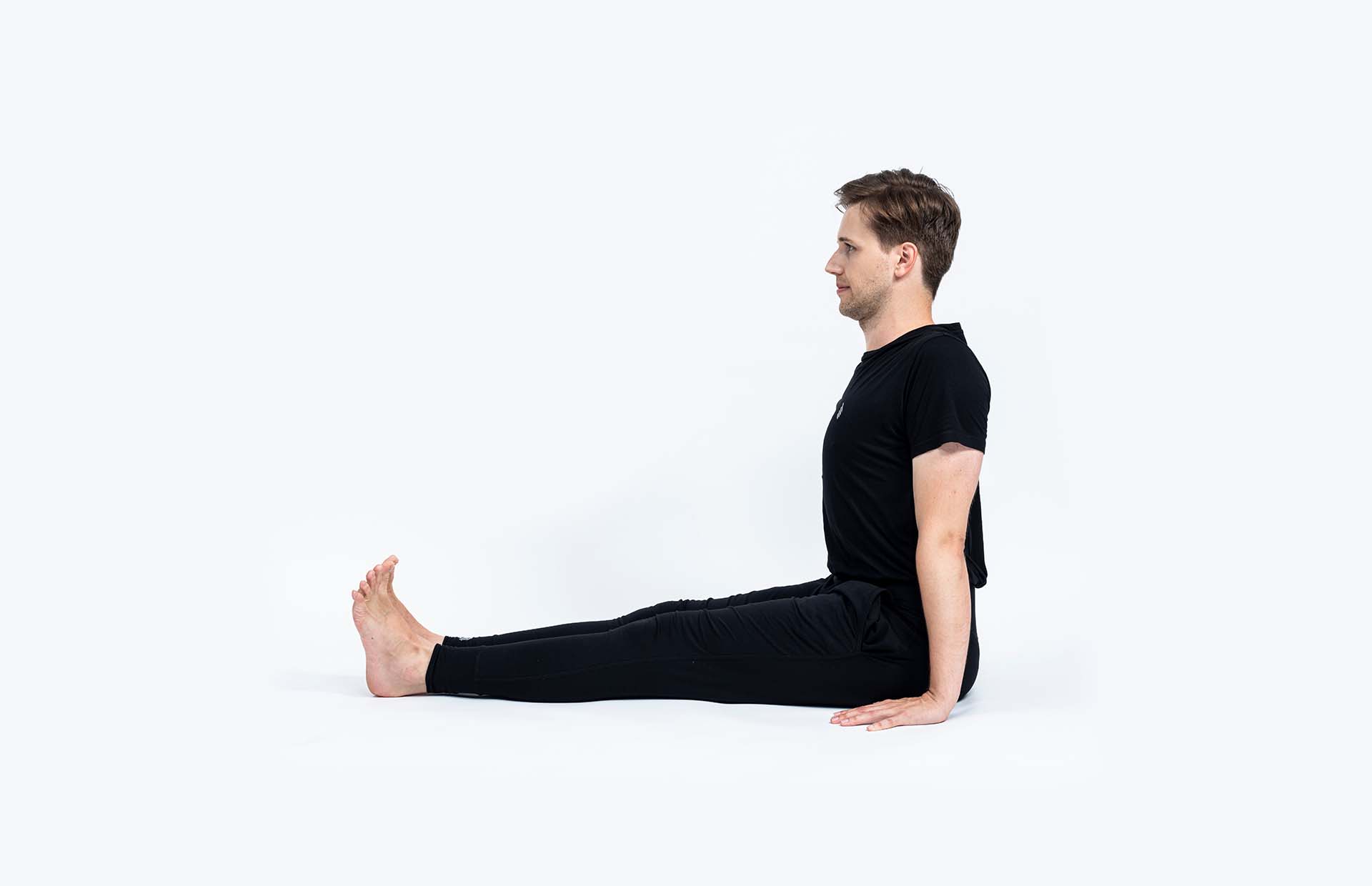A person sitting upright in Dandasana