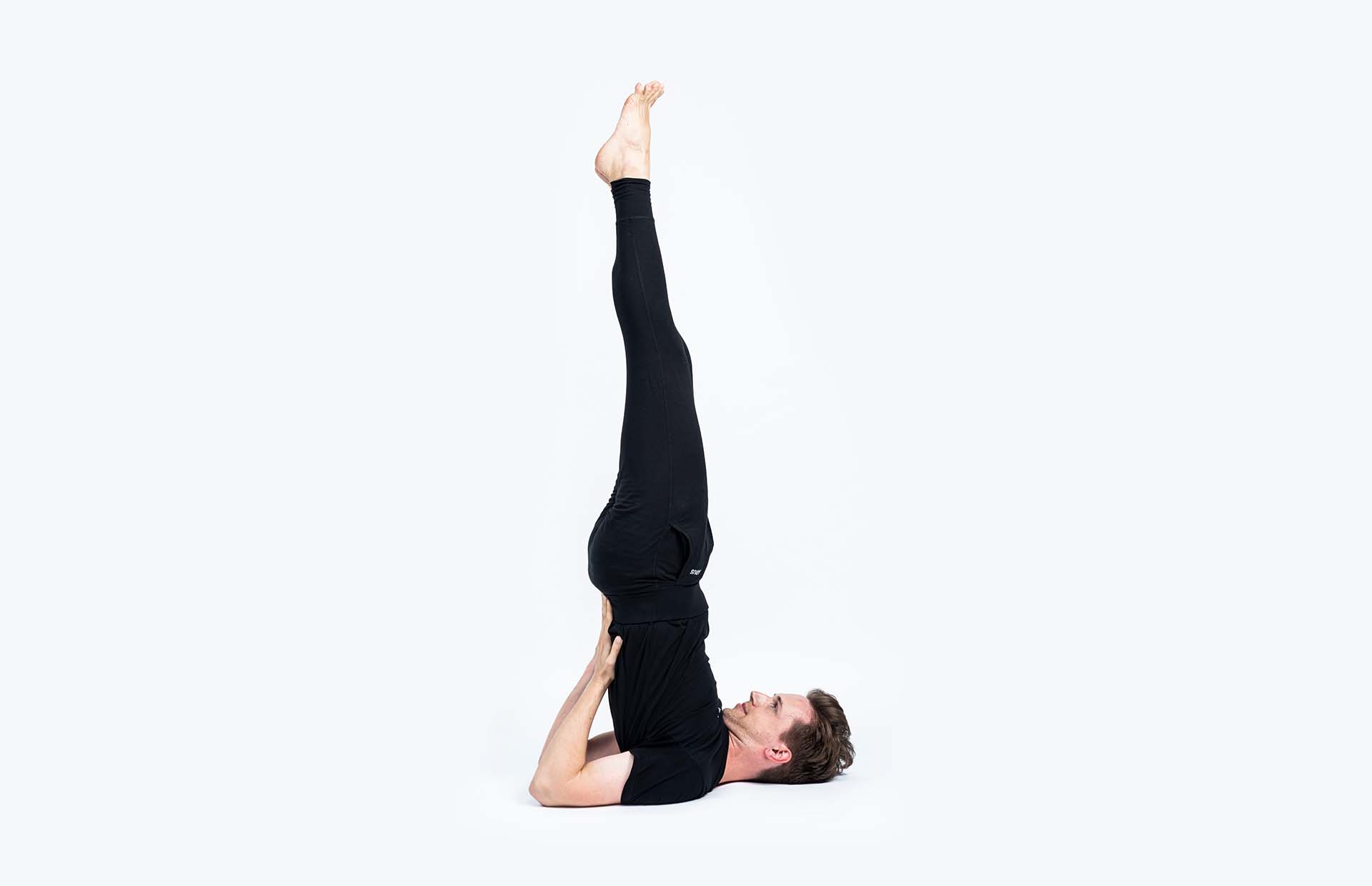 A person balancing in Sarvangasana (Shoulderstand)