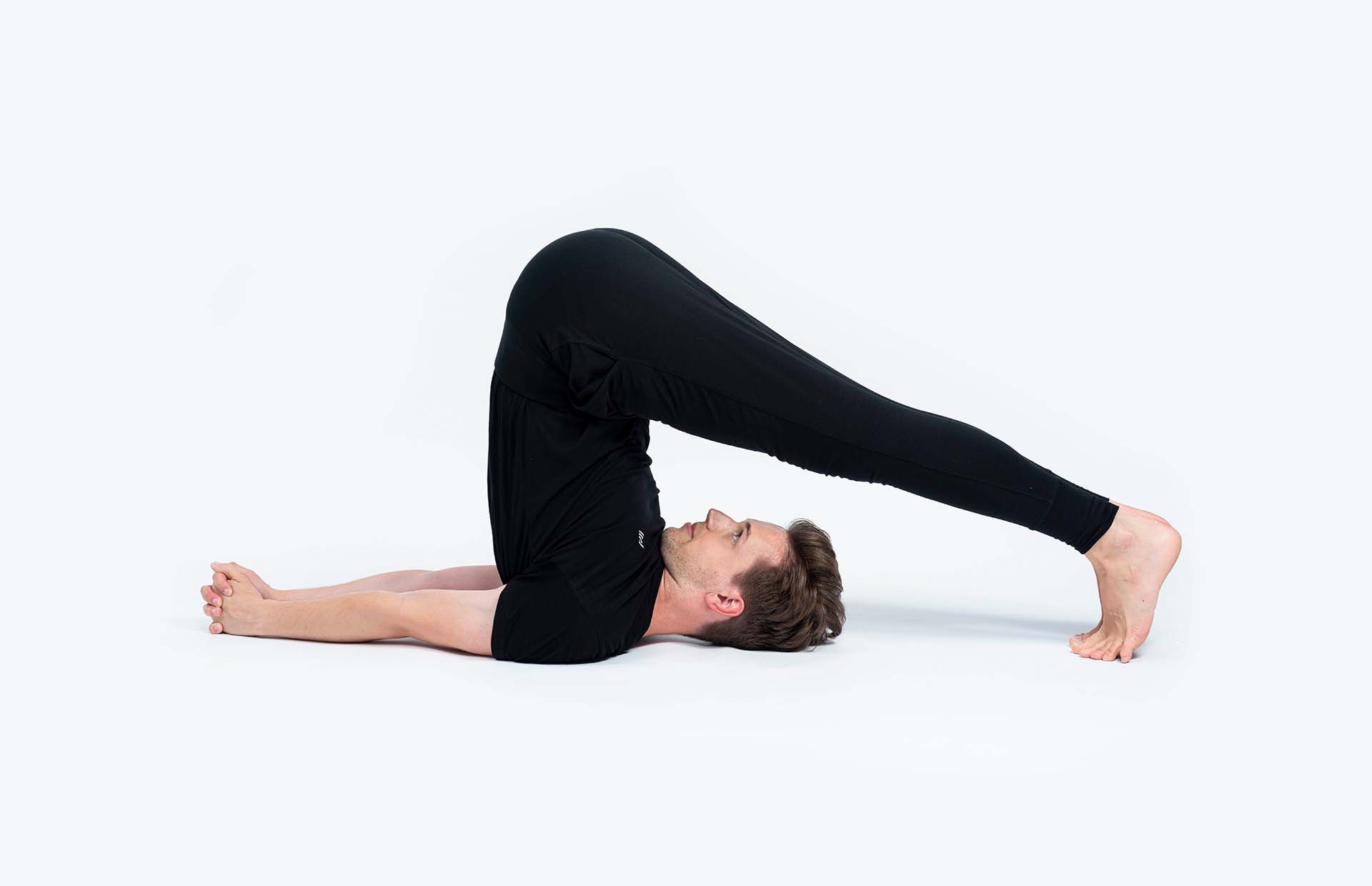 A person in Halasana (Plough Pose)