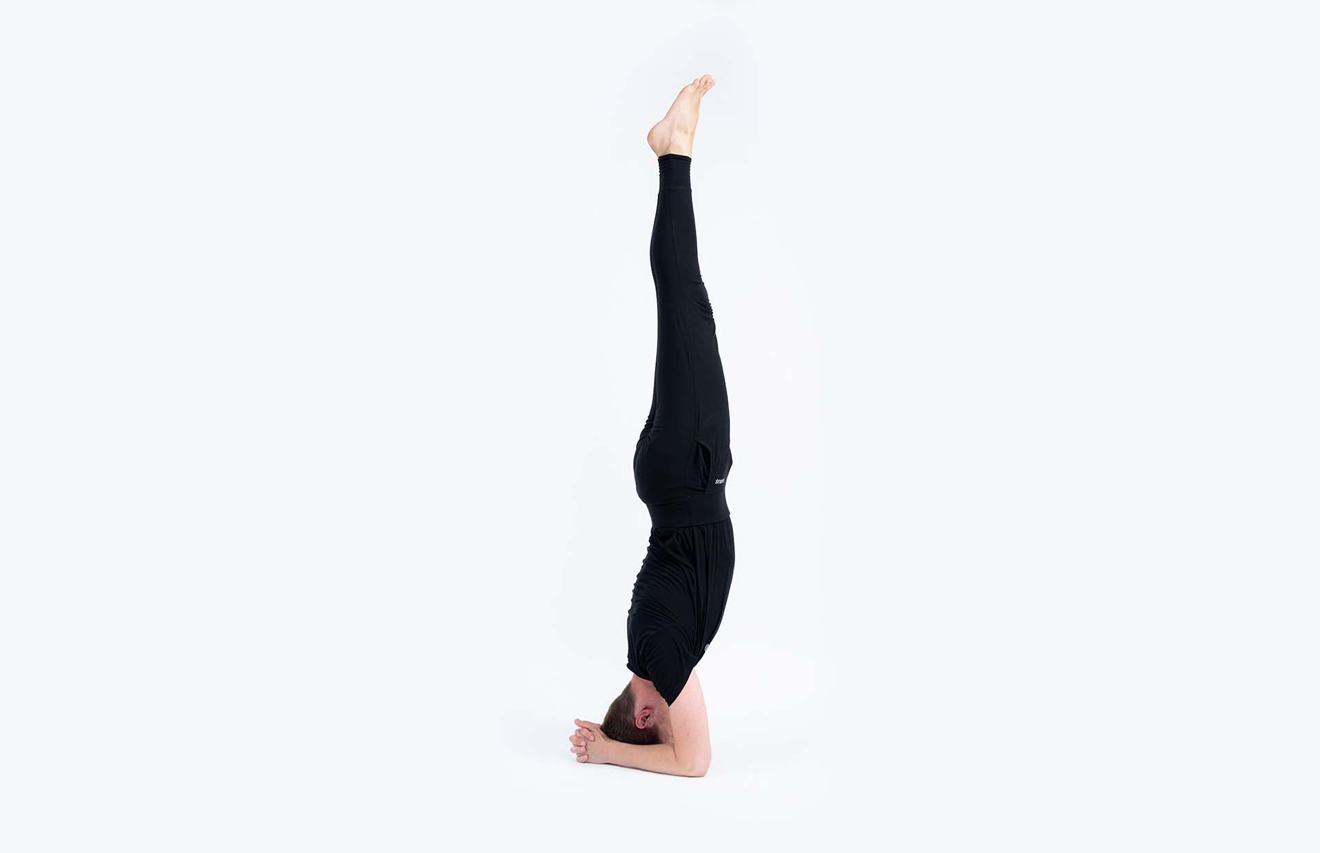 A person balancing in Sirsasana (Headstand)