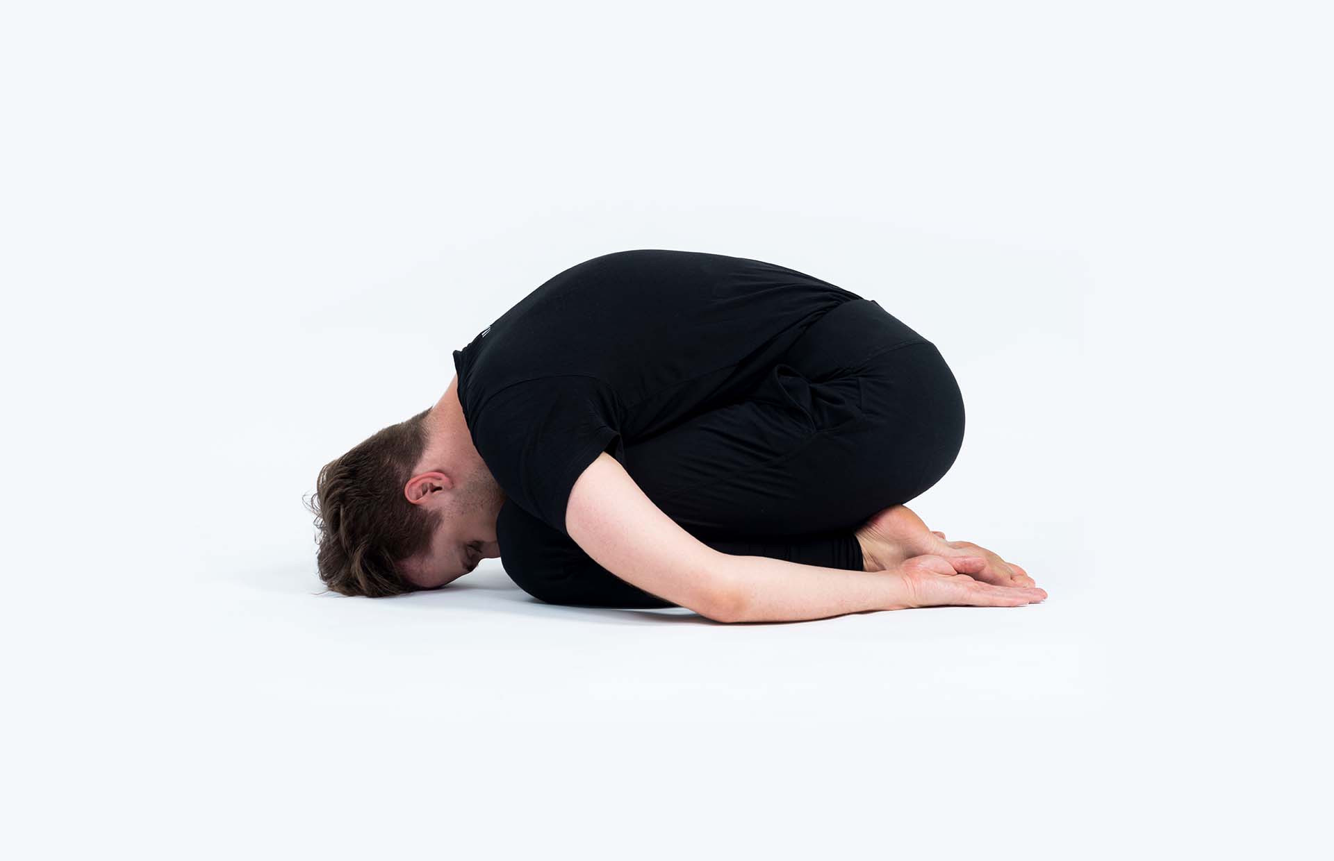 A person resting in child's pose (Balasana)